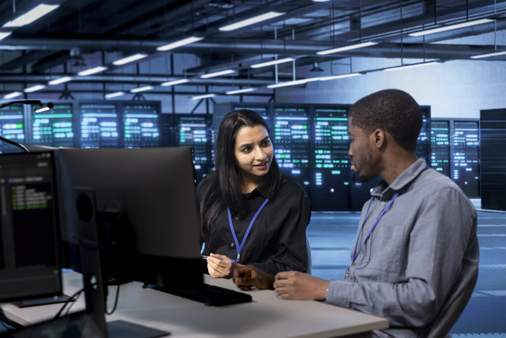 Two IT workers on computers at a business